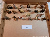 Top-down view showing 25 different Wade figurines arranged in a box, mostly animals and some human characters.