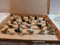 Box containing 25 assorted Wade animal figurines including dogs, birds, deer, buffalo, and others, arranged on cardboard inside an open box.