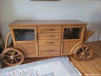 Front view showing mirrored cabinet doors on each side and four center drawers with wagon wheel accents