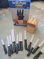 Photo shows the Wiltshire 13-piece cutlery set including a wooden block, multiple knives with black handles, and kitchen shears next to the product box.
