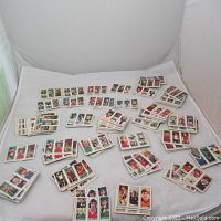 Wide view of white cloth surface covered with multiple stacks of trading cards