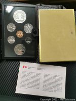 1977 Royal Canadian Mint Specimen coin set in black presentation case with protective cover and outer yellow storage box, alongside a bilingual information leaflet.