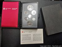 View of entire coin set with plastic case, red Royal Canadian Mint cover, and informational card