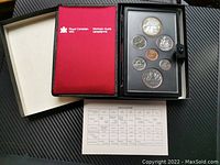 Full view of the coin set in black case with red lining and specification card below.