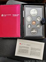 Full view of open case displaying all coins including the special edition silver dollar and certificate.