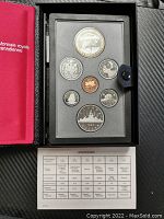 View of all seven coins including the special edition silver dollar in original black Royal Canadian Mint case with specifications card.