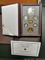 Overview of the 1995 Canada RCM silver proof coin set with special edition dollar in presentation box alongside Certificate of Authenticity.