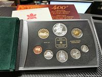 Full view of coin set in black foam insert inside protective display with outer packaging visible.