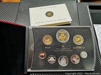 Photo of Canadian 2006 proof coin set in display case showing 8 coins along with presentation booklet in black box.