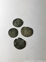 All four coins laid flat, obverse views visible