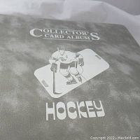 Gray vinyl binder cover printed “Collector’s Card Album Hockey” with skater graphic