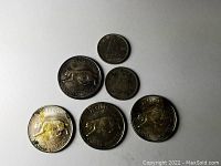 Six Canadian silver coins arranged on a flat white surface showing both clean and tarnished coins.