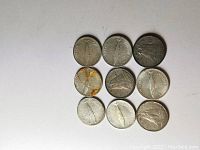 Nine Canadian silver dimes laid out in three rows of three on a white background, showing varying conditions and wear.