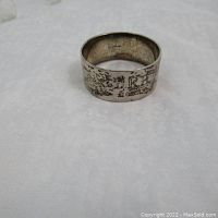 Front view of sterling silver napkin ring with worn texture and initials DRB showing surface oxidation and patina.