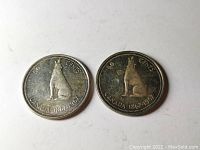Two Canada 1967 silver 50 cent coins laid flat showing the howling wolf design and inscriptions.