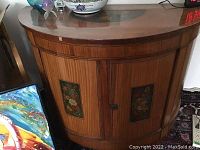 Full view of Italian curved demi lune cabinet in wood with two floral painted inlays on doors and a larger floral painted section on the top.