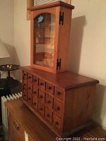 Overall view of medicine cabinet stacked on top of apothecary cabinet