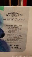 Close-up image of canvas label showing brand Windsor & Newton, size 44 x 56 inches, artists' quality stretched cotton canvas suitable for oil and acrylic paints.