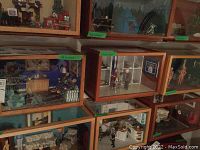 Photo of multiple dioramas stacked on shelves showing variety in scenes and sizes.