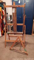 Full view of the large wooden floor easel standing upright showing its sturdy frame and adjustable features.