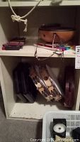 Shelf with five tambourines of different sizes and additional instruments including mini chimalong and xylophones, showing instrument collection