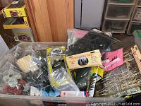 Plastic bin with various packaged and loose miniature tree models and foliage parts for village or architectural scale models.