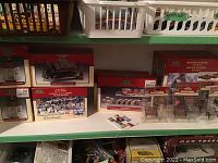 Photo of multiple LeMax Village Collection boxes with visible labels for wooden docks, park benches, colonial stone wall, duck pond, covered bridge, and gazebos.