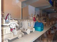 Wooden toy vehicles including a truck and a wagon placed on a shelf