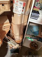 Wicker basket holding birch wood panels and boards along with wood dowels