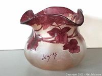 Front view of vase showing overall form, ruffled flute rim, and etched signature.