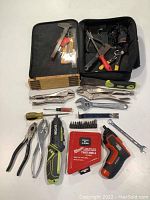 Full layout of the lot showing various hand tools including pliers, wrenches, screwdrivers, Ryobi cordless screwdriver, Milwaukee drill bits, and a folding ruler.
