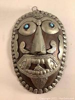 Front side of the Tibetan Kapala mask showing detailed silver metal facial features and blue accents on the eyes