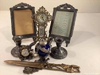 Photo of entire collection including two photo frames, candle holders, teapot, clocks, and letter opener
