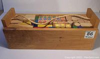 Wooden carrying case full of assorted wooden building blocks of various shapes and colors, tightly packed inside.