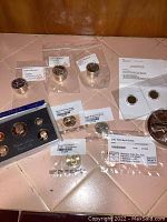 Overview of lot showing proof set, coin tubes, flips, uncirculated set, large silver rounds