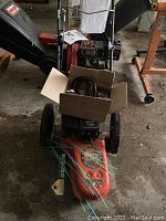 Orange and black DR stump grinder with accessories box on deck