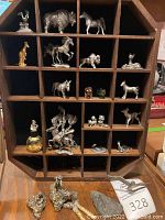 Full view of octagonal wooden curio cabinet with multiple small pewter figurines including a gold-tone kangaroo.