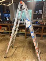 Photo of the assembled Gorilla Ladders professional 4-in-1 aluminum ladder in a workshop setting, showing the A-frame configuration and branding.