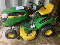 Front and side view of John Deere D105 auto riding lawn mower showing green and yellow body and yellow cutting deck