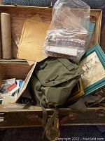 Overhead view of trunk showing canvas knapsack, correspondence, envelopes, framed photo and map tube