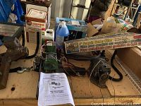 View of the winch on table with other items like container, blue tarps boxed, and gutter filter.