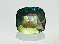 Close-up top view of the green sapphire on white background showing cut and color