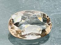 Close-up top view of the oval faceted peach pink morganite