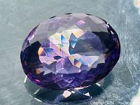 Close-up image of the oval cut Brazilian amethyst showing facets and luster.