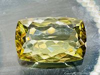 Close up view of the lemon quartz gemstone showing its yellow color and faceted cut.