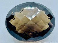 Close-up front view of the fancy oval checker cut Smokey Quartz displaying its faceting pattern and deep smoky color.