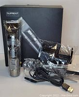Photo shows Suprent hair clippers set with metallic clipper, four black guide combs, USB charging cable, grooming comb, all placed in front of black product box with image and Suprent branding.