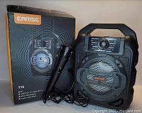Photo showing Carise T15 wireless speaker, wired microphone, and original product box.