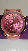 Front view of the Genova wristwatch showing the pink dial, gold-tone case, Roman numerals, sub-dials, and light pink leather strap.