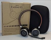 Jabra Evolve 65 wireless headset shown outside original product box with black zippered carrying case beside it.